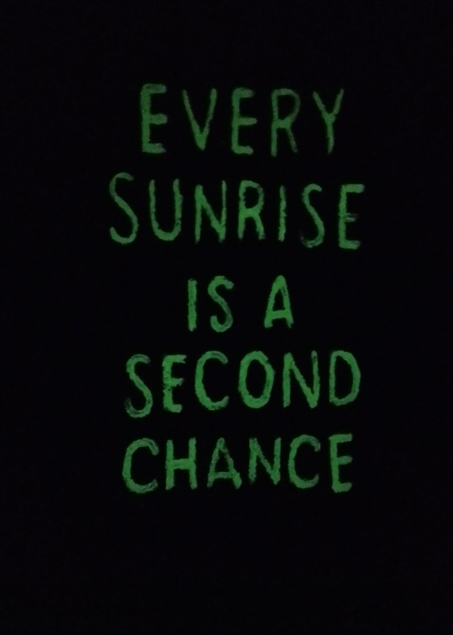 Glow-in-the-dark version of inspirational sunrise painting with quote Every Sunrise Is a Second Chance illuminated softly