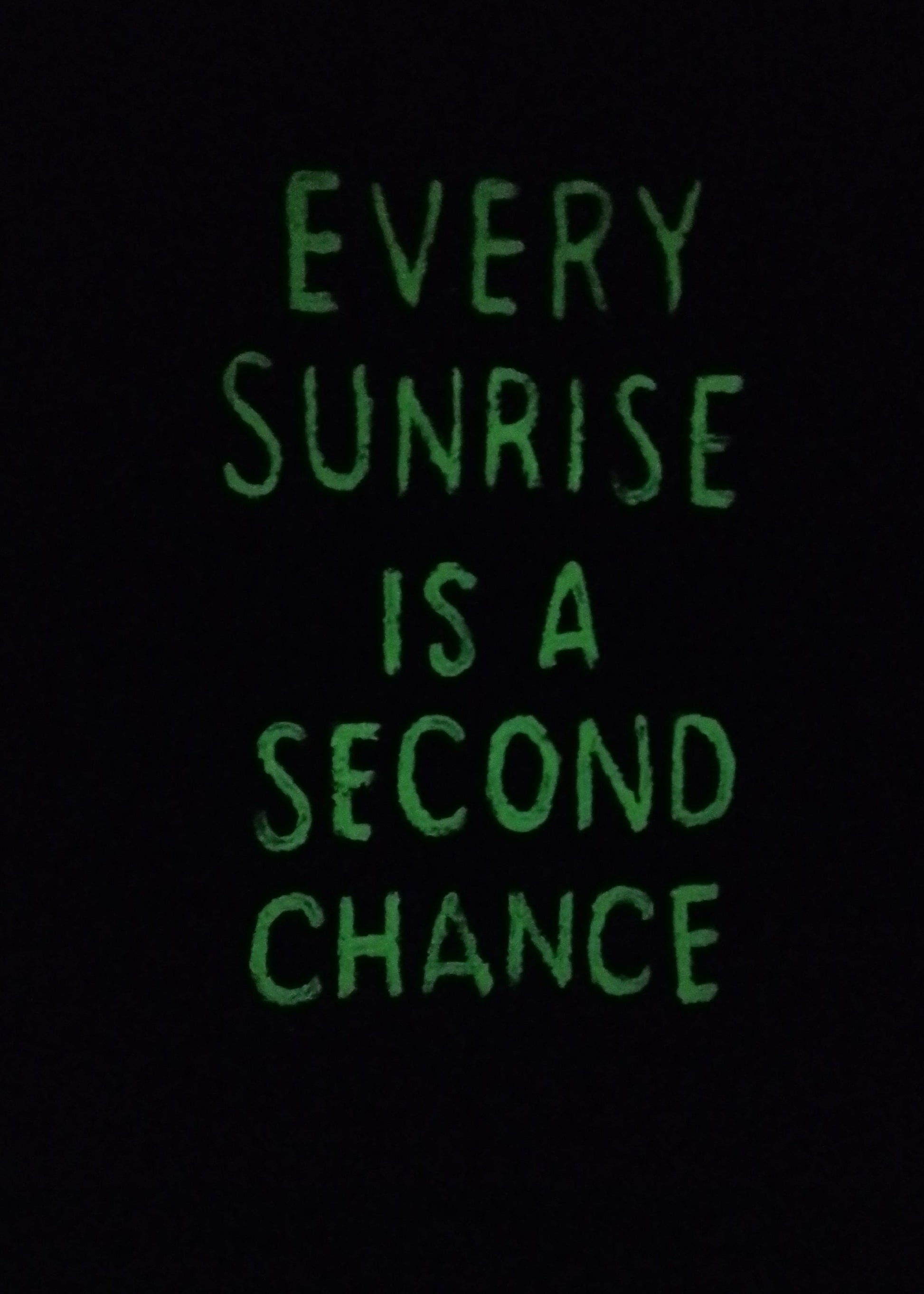 Glow-in-the-dark version of inspirational sunrise painting with quote Every Sunrise Is a Second Chance illuminated softly