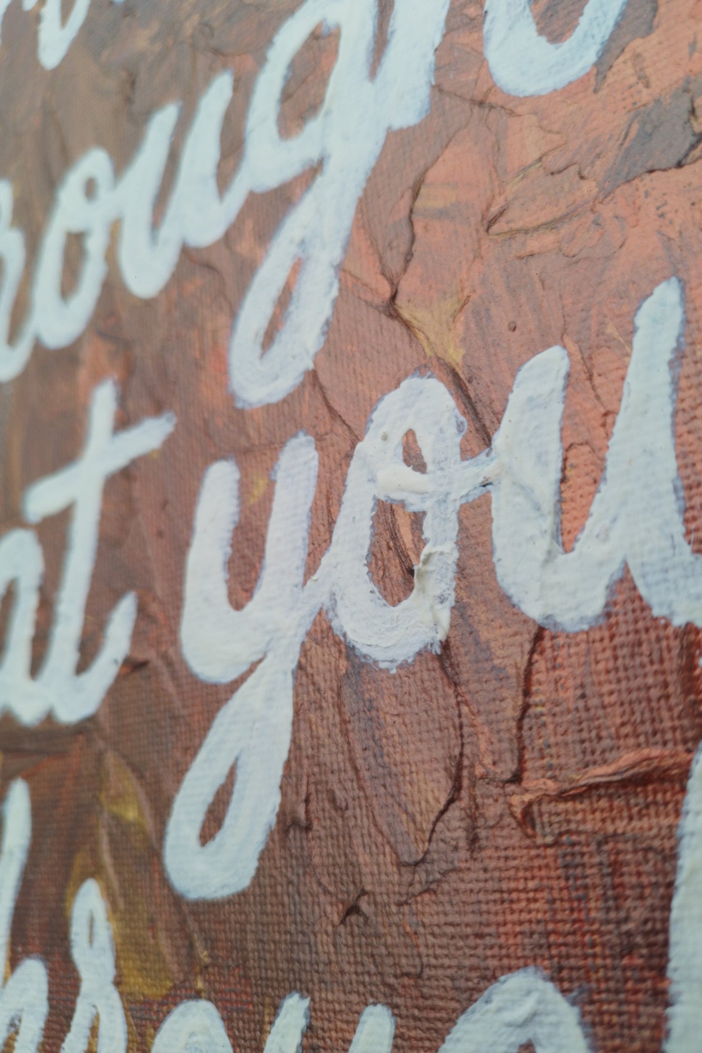 “Close-up of textured brush strokes and white lettering on expressionist painting ‘Grow Through What You Go Through’ glow in the dark.”