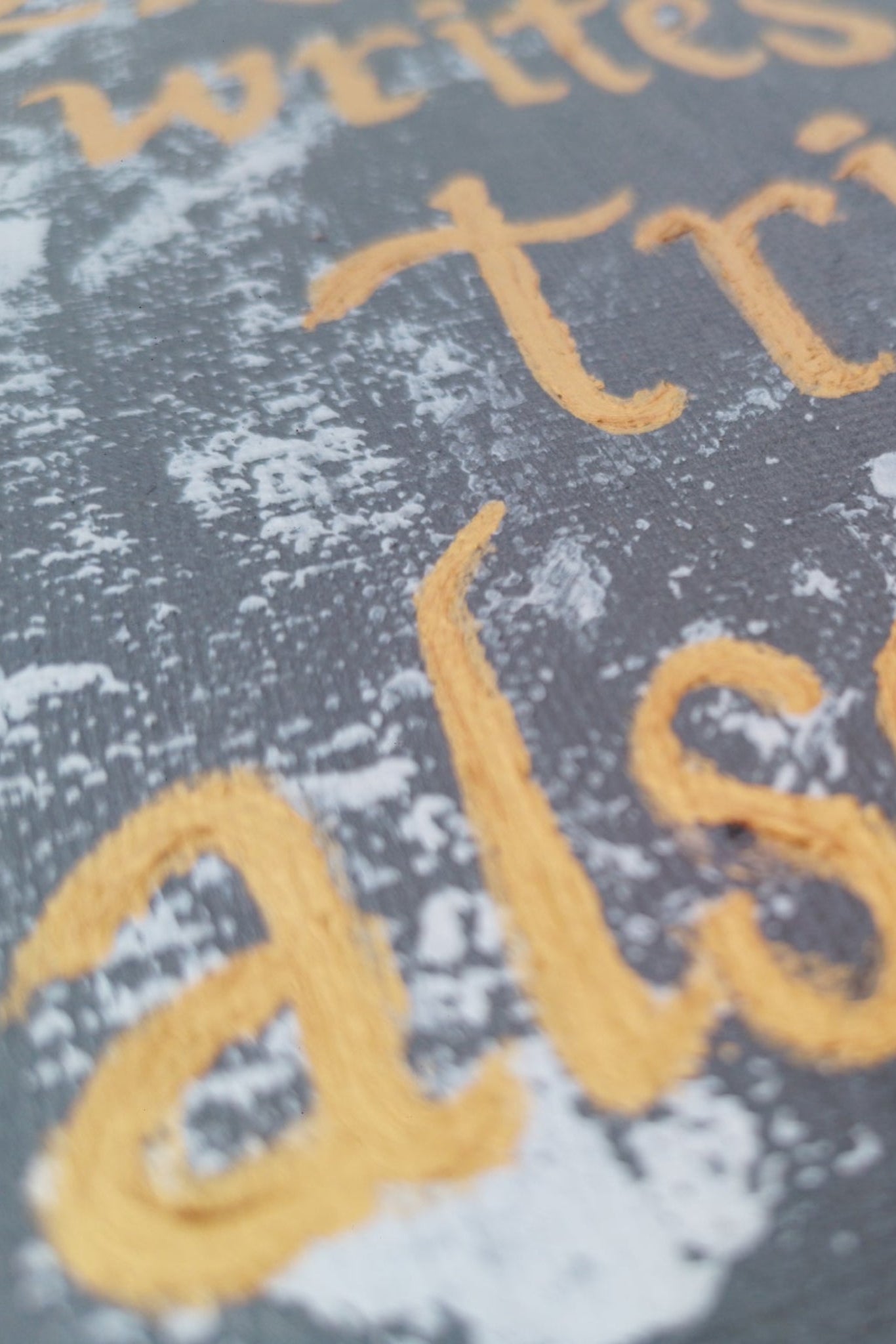 Acrylic painting of  Textured surface with golden text on a dark background